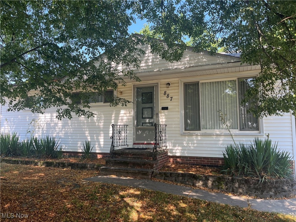 White ranch home under mature trees at 887 McKinley Ave, Bedford, Ohio